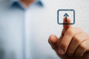 A person is using their fingertip to touch an upward arrow icon displayed on a surface. The environment appears to be a professional office, suggesting an emphasis on technology and communication. photo