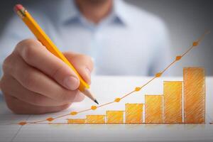 A person is holding a yellow pencil and creating a simple bar graph on a sheet of paper. The graph displays ascending bars symbolizing growth, showcasing a professional environment. photo