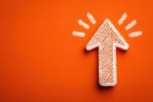 A textured upward arrow stands out against a bright orange background. The arrow is depicted in a chalk-like style and emphasizes a sense of direction and progress within a simplified design. photo