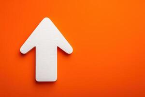 A white arrow points upwards against a bold orange background, creating a striking visual contrast. The design suggests movement and directionality, perfect for guiding attention. photo