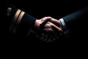 A close-up view of two hands engaged in a handshake, one adorned with a military uniform and the other in a formal suit, symbolizing unity and cooperation in a solemn atmosphere. photo