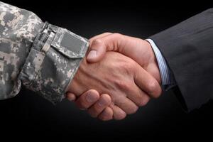 A military member in camouflaged uniform shakes hands with a civilian in a formal suit. This gesture symbolizes unity, cooperation, and an understanding between diverse sectors. photo
