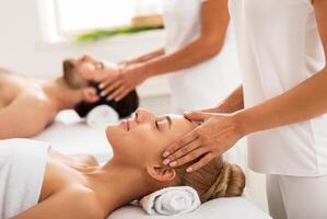 Couple Enjoying Head Massage Together, Lying On Beds With Eyes Closed At Spa Center Indoors. Wellness And Relaxation Procedure, Beauty Spa Day Concept. Selective Focus photo