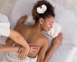 Woman relaxing and having back massage in spa salon, top view photo