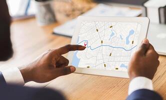 Unrecognizable Black Businessman Using Taxi Services App On Digital Tablet In Office, Looking At Virtual Map With GPS Trackers, Checking Nearest Cab, Creative Collage For Transportration Concept photo