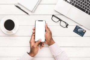 Hand using smartphone with blank screen on white wooden background, top view, copy space photo
