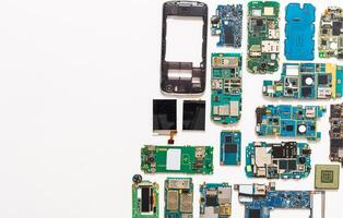 Mobile repair flat lay background. Dissasembled smartphone top view, copy space. Technician workplace with instruments and cell phone components photo