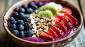 Colorful fruit and granola bowl with purple smoothie. photo
