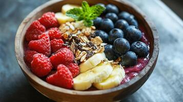 Colorful fruit and granola topped smoothie bowl in wooden bowl. photo