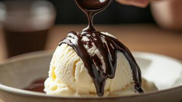 Close-up view of vanilla ice cream topped with dark chocolate sauce. photo