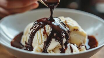 Creamy vanilla ice cream topped with rich chocolate sauce. photo