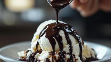 Rich, decadent scoop of ice cream topped with chocolate sauce. photo