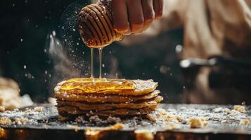 Honey dripping onto a stack of golden pancakes. photo