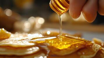 Honey being poured over a stack of pancakes. photo