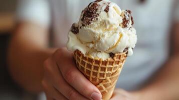 Delicious scoop of vanilla and chocolate ice cream in a waffle cone. photo
