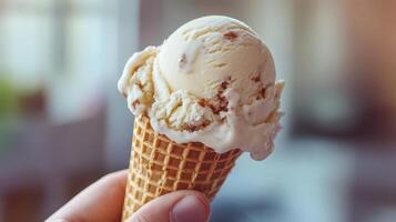 Creamy vanilla ice cream scoop in a waffle cone. photo