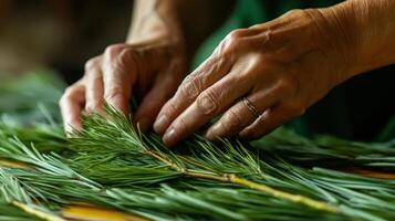 Hands arranging fresh pine boughs on a surface. photo