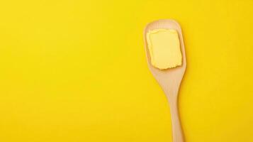 A golden butter block on a wooden spoon, perfect for your culinary creations. photo
