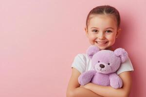 Smiling Girl with Teddy Bear on Pink Background photo