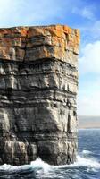 Majestic Coastal Cliffs Dramatic Ocean Waves Crashing Against Ancient Rock Formations. A Breathtaking Seascape of Nature's Power and Beauty photo