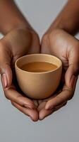 A Delicate Offering Warm Liquid Held in Tender Hands. A Stunning of a Handcrafted Ceramic Cup Filled with a Warm Beverage, Capturing the Essence of Tranquility and Hospitality. photo