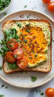 A plate with a sandwich on it with tomatoes and avocado photo