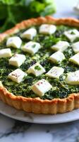 A quiche with cheese and spinach on a white plate photo