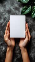 Hands holding a blank white card on a dark background photo