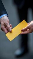 A View of Two Hands Exchanging a Gold Card A Symbol of Business Transactions, Deals, and Agreements. The image evokes the sense o photo