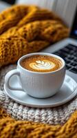 Aromatic Coffee in a Cozy Knit Setting Indulge in the warmth of a perfectly crafted latte, surrounded by soft textures and the com photo