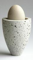 Speckled Ceramic Egg Cup A Still Life Study in Minimalist Design. The image showcases a pristine white egg nestled within a speck photo