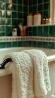 A Luxurious Bathroom Setting Soft White Towels on a Vintage Style Tub, Green Tiled Walls, and Serene Ambiance. Perfect for Relaxat photo