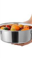 A hand holding a stainless steel pot filled with fresh, colorful fruits and vegetables. The image evokes a sense of healthy eating photo