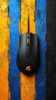 A Black and Orange Gaming Mouse on a Vibrant Blue and Yellow Painted Wall Background. This high resolution image showcases the sle photo