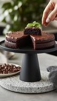A cake is being cut into pieces on a cake stand photo
