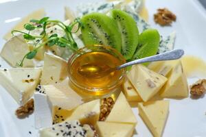 Cheese kiwi honey Appetizer Platter with Assorted Cheeses, Crackers, and Olives photo