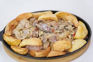Mushrooms potatoes meat close-up. Roast with a potato, meat and mushrooms and vodka in a transparent photo