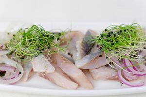 herring Salted marinated herring fillet with spices and green onion photo