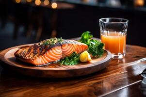 Closeup salmon steak with glass of juice on wood table photo