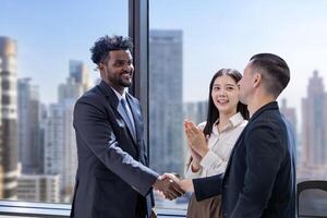 Team of diversity business people having agreement and handshake over new strategic strategy project deal on investment real estate with recognition and applause from other colleague for partnership photo