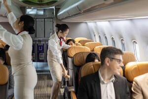 Asian female flight attendant adjusting seat back upright position after passengers are seat and prepare to take off for airline travel and safety protocol procedure photo