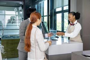 Couple passengers are getting their boarding pass from airline ground crew at departure gate into the airplane for final inspection before boarding into the plane photo