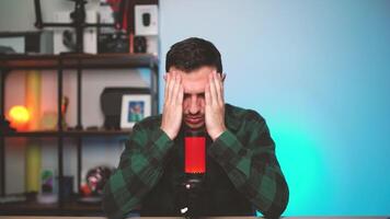 Frustrated Content Creator Sitting at Desk with Hands on Head Struggling with Creative Block video