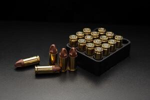 A set of 9mm ammunition rounds for pistols and PCC carbines, elegantly arranged on a shadowed backdrop. photo