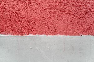 A wall with a red and white stripe. The red stripe is painted on top of the white. photo