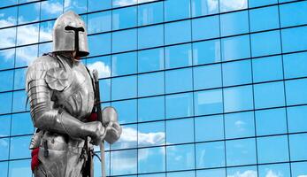 Knight in shiny metal armor. Reliable security and insurance. Clouds are reflected in the mirror wall of a skyscraper. Copy space. photo