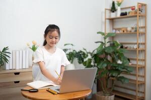 Back to School girl studying with notebook and laptop in bright room photo