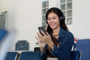 Journey excitement with woman using smartphone and headphones at airport photo