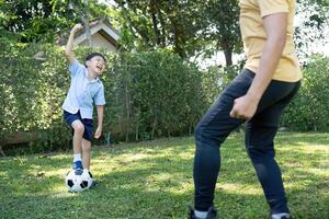 Activity. Young Boy Having Fun Kicking a Soccer Ball with Dad photo