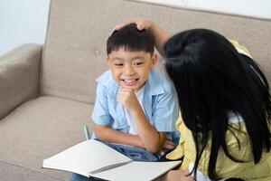 Back to School. Child smiling while studying with mother at home. photo